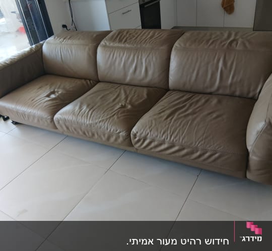 ספה חומה על רצפת אריחים לבנה